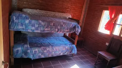 a bedroom with two bunk beds and a chair at La Rufina Casa De Campo in Potrero de Garay
