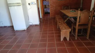 a kitchen with a table and a table and a refrigerator at La Rufina Casa De Campo in Potrero de Garay