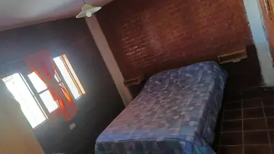 a bedroom with a bed and a brick wall at La Rufina Casa De Campo in Potrero de Garay