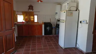 a kitchen with a white refrigerator and a tile floor at La Rufina Casa De Campo in Potrero de Garay