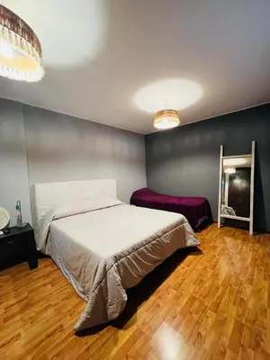 a bedroom with a white bed and a mirror at Carlos Paz Hostel Lodge in Villa Carlos Paz