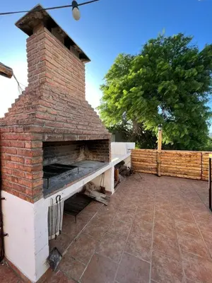 an outdoor brick pizza oven on a patio at Carlos Paz Hostel Lodge in Villa Carlos Paz