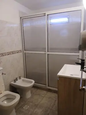 a bathroom with a toilet and a shower and a sink at Carlos Paz Hostel Lodge in Villa Carlos Paz