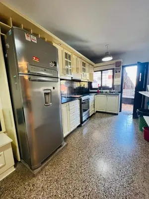a kitchen with a stainless steel refrigerator and cabinets at Carlos Paz Hostel Lodge in Villa Carlos Paz