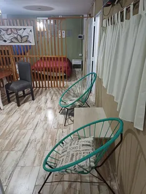 a living room with two chairs and a couch at Altos Aparts cabañas in Estancia Vieja
