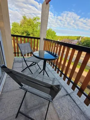 a patio table and a chair on a balcony at Altos Aparts cabañas in Estancia Vieja