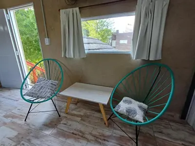 two chairs and a bench in a room with a window at Altos Aparts cabañas in Estancia Vieja