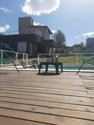 a ping pong table on a deck next to a pool at Altos Aparts cabañas in Estancia Vieja