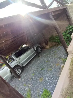 a car is parked under a pergola at Altos Aparts cabañas in Estancia Vieja
