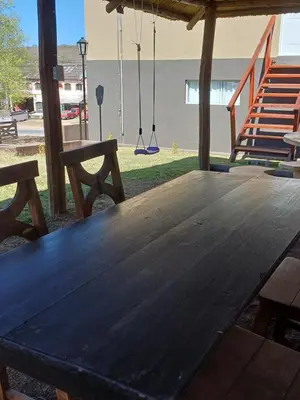 a wooden picnic table with a swing at Altos Aparts cabañas in Estancia Vieja