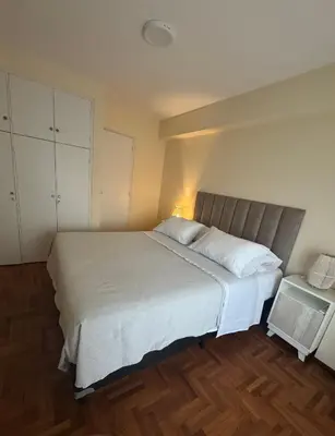 a bedroom with a large white bed and a table at Av Poeta Lugones - Nueva Córdoba in Cordoba
