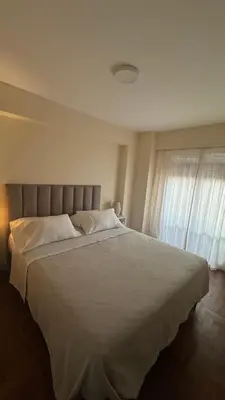 a bedroom with a large white bed and a window at Av Poeta Lugones - Nueva Córdoba in Cordoba