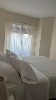 a bedroom with a bed with pillows and a window at Av Poeta Lugones - Nueva Córdoba in Cordoba