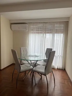 a dining room with a glass table and chairs at Av Poeta Lugones - Nueva Córdoba in Cordoba