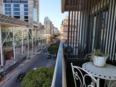 a balcony with a table and chairs on a city street at Departamento 1 dormitorio ubicado en zona estratégica de Nueva Córdoba in Cordoba