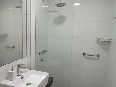 a white bathroom with a sink and a shower at Departamento 1 dormitorio ubicado en zona estratégica de Nueva Córdoba in Cordoba