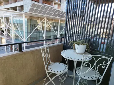 a balcony with two chairs and a table and a window at Departamento 1 dormitorio ubicado en zona estratégica de Nueva Córdoba in Cordoba