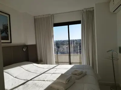 a bedroom with a bed and a large window at Departamento 1 dormitorio ubicado en zona estratégica de Nueva Córdoba in Cordoba