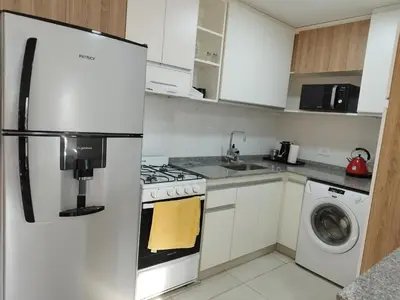 a kitchen with a refrigerator and a washer and dryer at Departamento 1 dormitorio ubicado en zona estratégica de Nueva Córdoba in Cordoba
