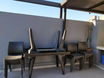 a laptop computer sitting on a table with chairs at Departamento 1 dormitorio ubicado en zona estratégica de Nueva Córdoba in Cordoba