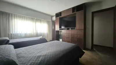 a hotel room with two beds and a flat screen tv at Casa colores fotheringham in Río Cuarto
