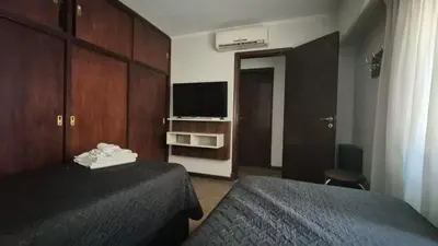a hotel room with two beds and a television at Casa colores fotheringham in Río Cuarto
