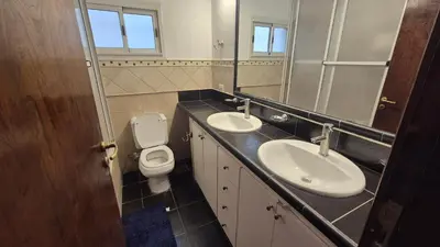 a bathroom with two sinks and a toilet and a mirror at Casa colores fotheringham in Río Cuarto