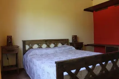 a bedroom with a wooden bed and two night stands at Cabañas Chakra Raiz in Pantanillo