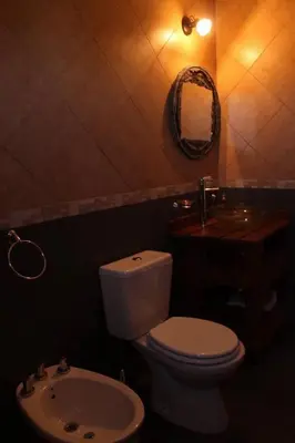 a bathroom with a toilet and a sink and a mirror at Cabañas Chakra Raiz in Pantanillo
