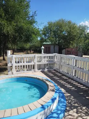 a white fence next to a swimming pool at Cabañas Chakra Raiz in Pantanillo
