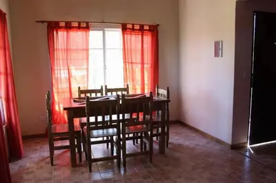 a dining room with a table and chairs and a window at Cabañas Chakra Raiz in Pantanillo