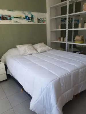 a large white bed sitting in a room at Dean Funes - Distrito monoambiente in Cordoba