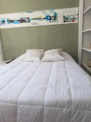 a white bed with two pillows on top of it at Dean Funes - Distrito monoambiente in Cordoba