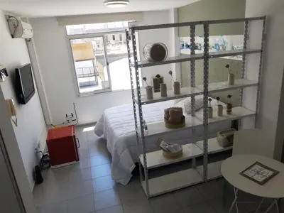 a room with a bed and a shelf with hats at Dean Funes - Distrito monoambiente in Cordoba
