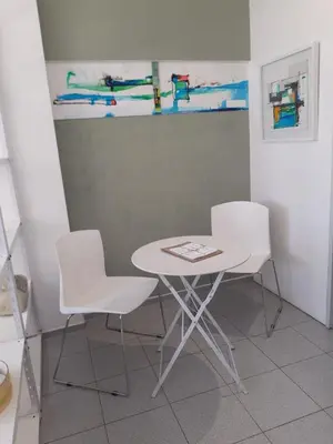 a white table and two white chairs in a room at Dean Funes - Distrito monoambiente in Cordoba