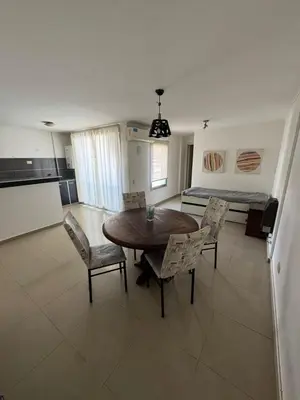 a living room with a table and chairs and a bed at Pringles - 1 dormitorio Bº General Paz in Cordoba