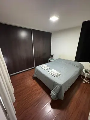a bedroom with a bed and a wooden floor at Pringles - 1 dormitorio Bº General Paz in Cordoba