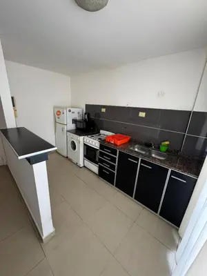 a large kitchen with a stove and a microwave at Pringles - 1 dormitorio Bº General Paz in Cordoba
