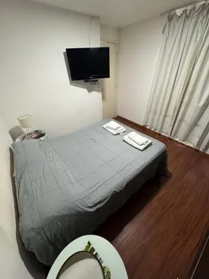 a bedroom with a bed with a toilet and a tv at Pringles - 1 dormitorio Bº General Paz in Cordoba