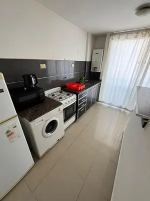 a kitchen with a stove and a washing machine at Pringles - 1 dormitorio Bº General Paz in Cordoba