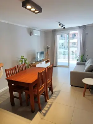 a living room with a wooden table and chairs at Departamento moderno en Barrio General Paz in Cordoba