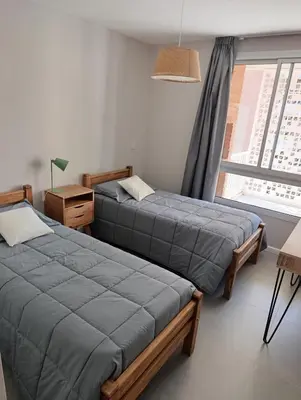 two beds in a room with a window at Departamento moderno en Barrio General Paz in Cordoba