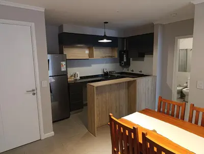 a kitchen with a stainless steel refrigerator and a table at Departamento moderno en Barrio General Paz in Cordoba