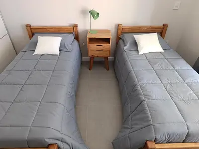 two beds sitting next to each other in a room at Departamento moderno en Barrio General Paz in Cordoba
