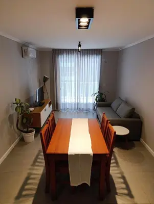 a living room with a table and a couch at Departamento moderno en Barrio General Paz in Cordoba