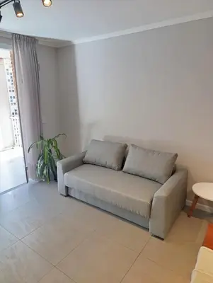 a couch sitting in a living room with a window at Departamento moderno en Barrio General Paz in Cordoba