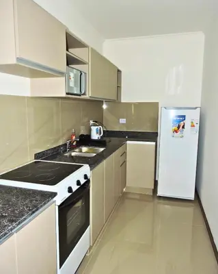 a kitchen with a stove and a refrigerator at Atardecer urbano en el corazón de Carlos Paz in Villa Carlos Paz