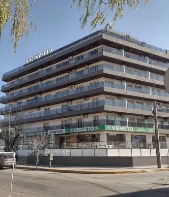 a large office building with a sign on it at Atardecer urbano en el corazón de Carlos Paz in Villa Carlos Paz