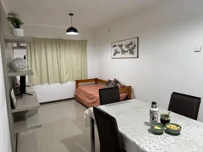 a room with a table with chairs and a bed at Atardecer urbano en el corazón de Carlos Paz in Villa Carlos Paz