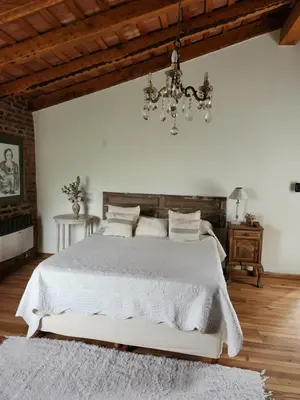 a bedroom with a white bed and a chandelier at Descanso Serrano in Las Rabonas